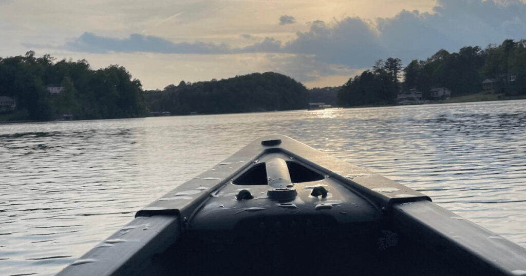 A canoe on a lake with trees in the background.