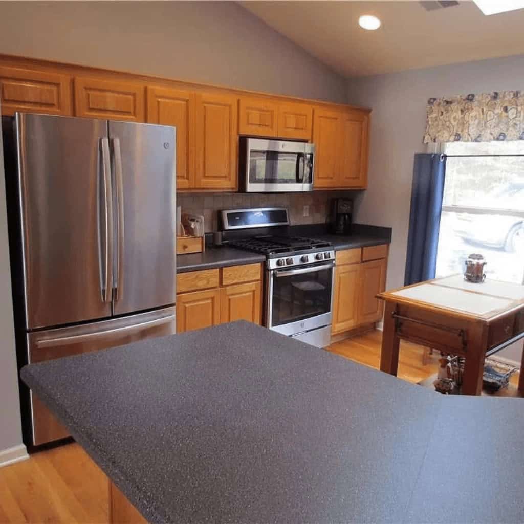 A kitchen with stainless steel appliances and wooden cabinets.