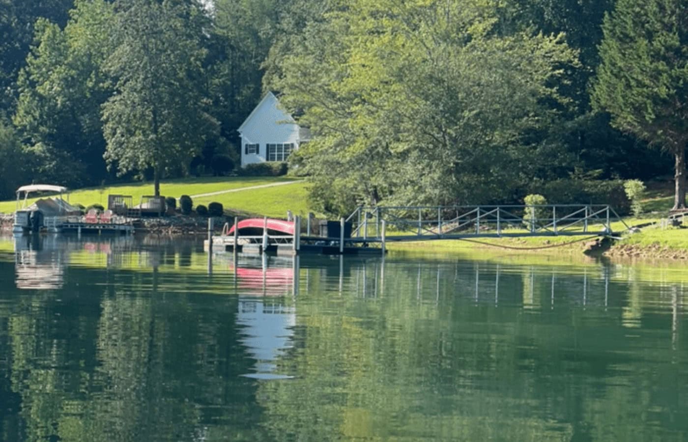 A boat docked on a lake near a house.